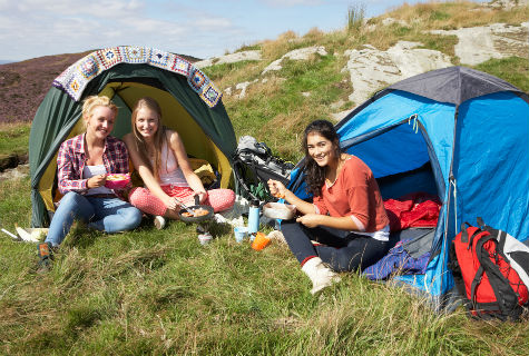 Campers sitting in their tents on a hill