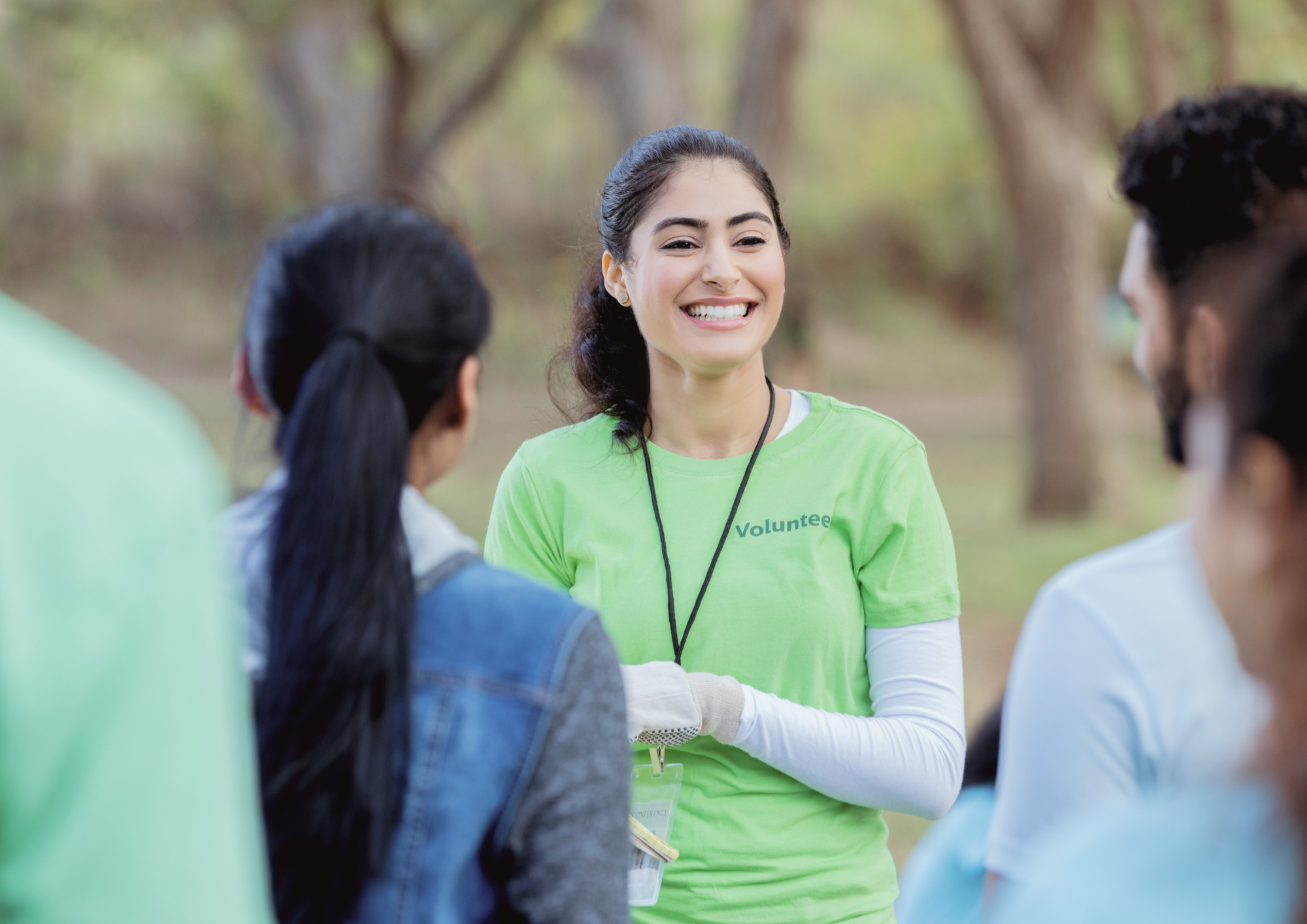 Volunteer speaking with a group outdoors