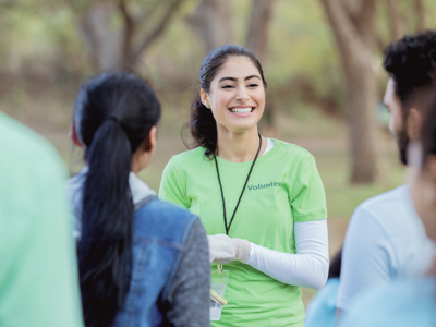 Volunteer speaking with a group outdoors