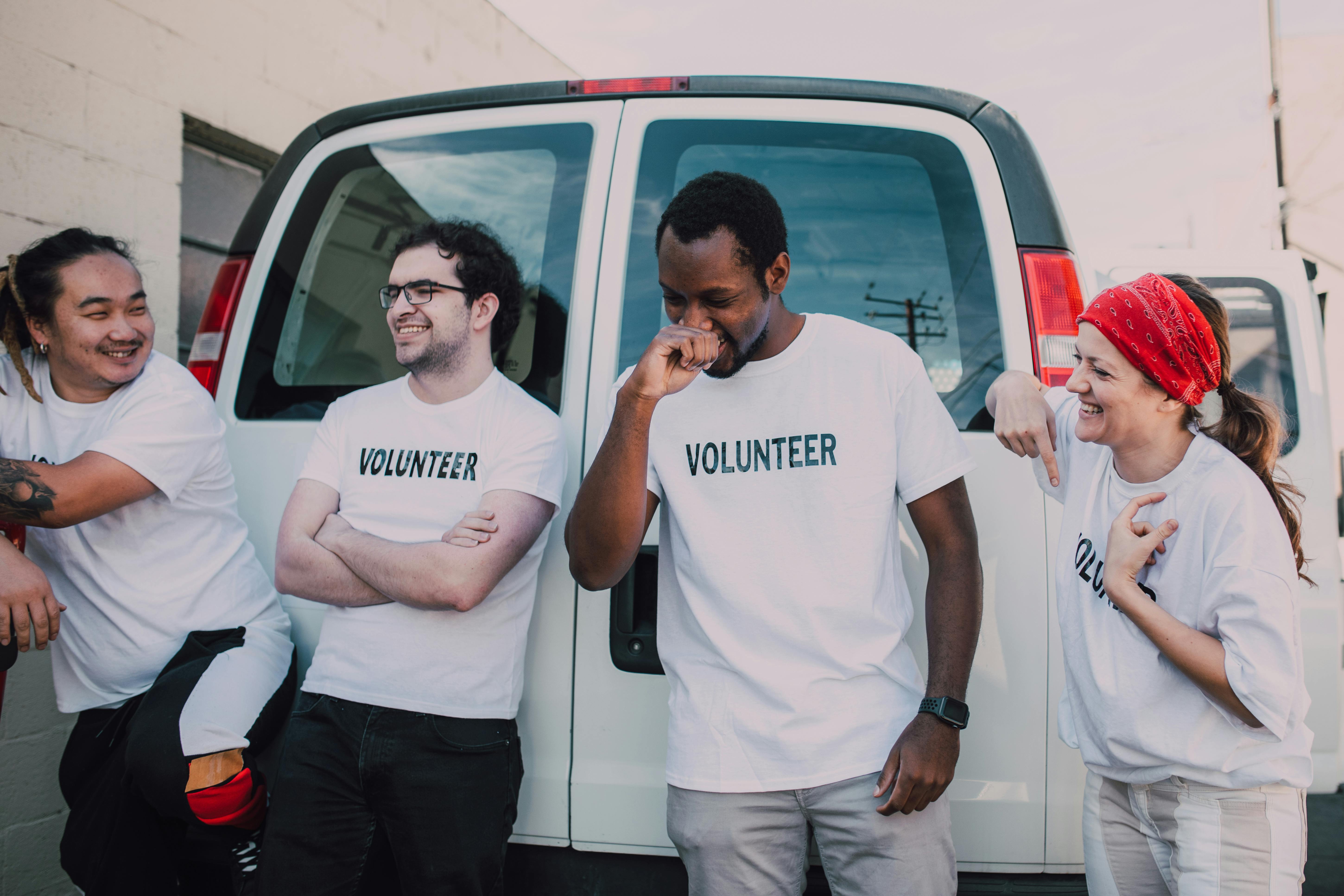 Volunteers laughing by a van