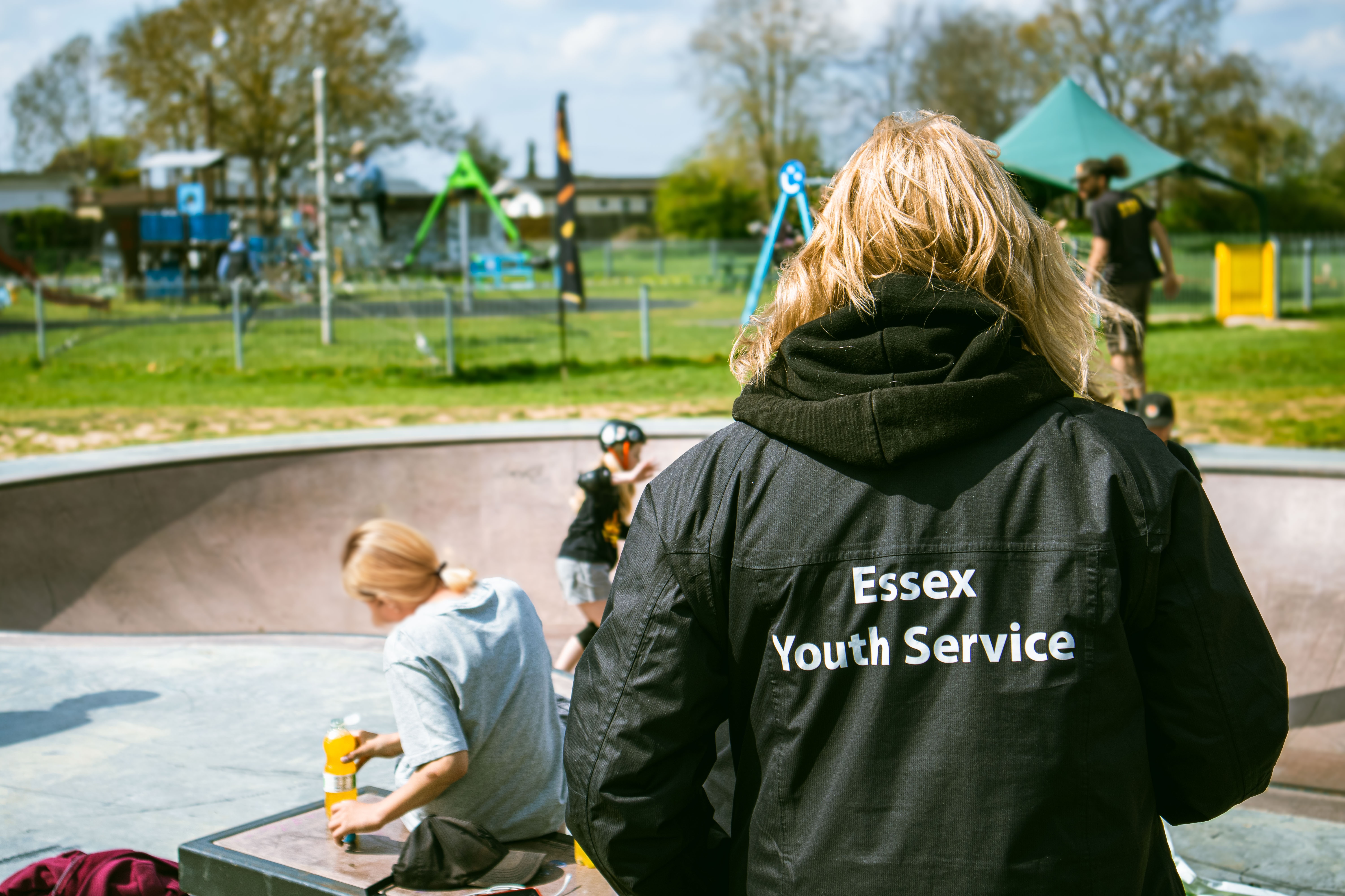 Essex Youth Service worker at a skatepark with young people using the facilities